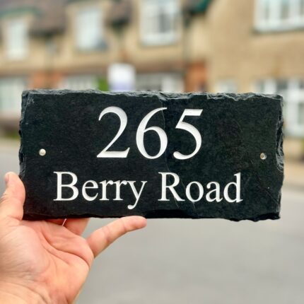 Rustic slate house sign with street name and house number.